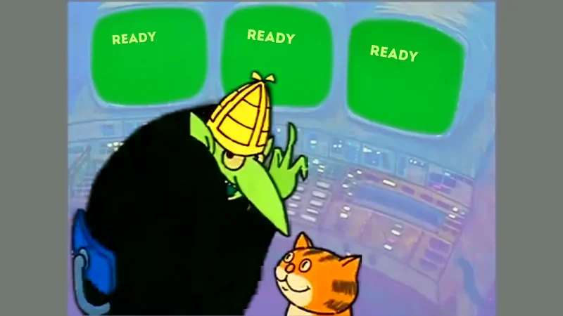 A green cartoon character operates a control console while an orange cat watches; three monitors above them read ‘READY’